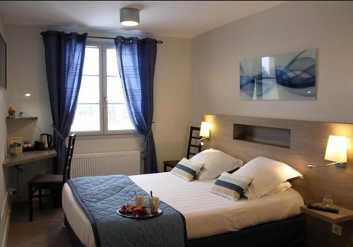 a hotel room with a bed and a window at Logis Hotel Restaurant La Croisée des Chemins in Cayres