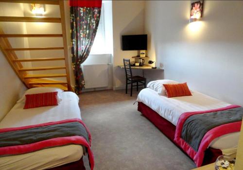 a room with two beds and a desk and a window at Logis Hotel Restaurant La Croisée des Chemins in Cayres