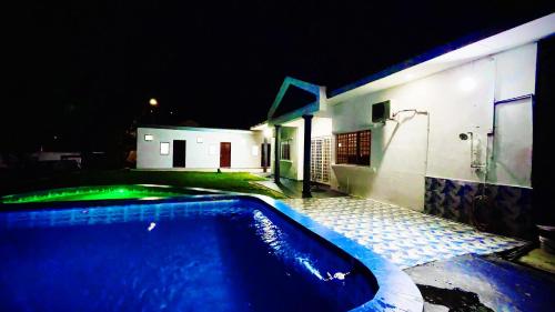 - une piscine en face d'une maison la nuit dans l'établissement PD Best Homestay, à Port Dickson