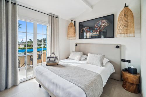 sypialnia z łóżkiem i widokiem na ocean w obiekcie Hôtel La Nartelle w miejscowości Sainte-Maxime