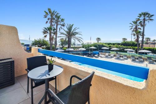 d'un balcon avec une table et des chaises, ainsi que d'une piscine. dans l'établissement Hôtel La Nartelle, à Sainte-Maxime