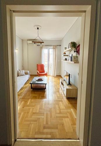 een woonkamer met een houten vloer en een bank bij Bella Vista Apartment in Chios
