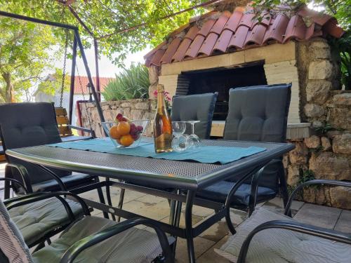 a table with a bottle of wine and a bowl of fruit at Apartments Dora in Crikvenica