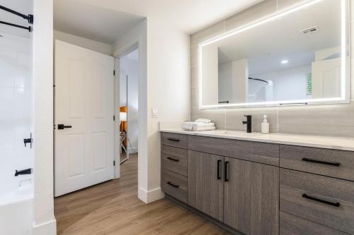 La salle de bains est pourvue d'un lavabo et d'un miroir. dans l'établissement CozySuites at Kierland Commons with pool #13, à Scottsdale