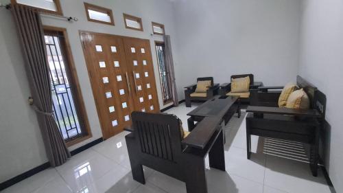 a room with couches and tables and chairs and windows at Green ijen homestay and tour in Banyuwangi
