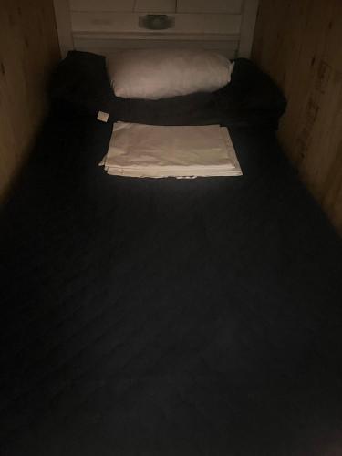 two twin beds in a small room with black flooring at Hostel Bedgasm in Tokyo