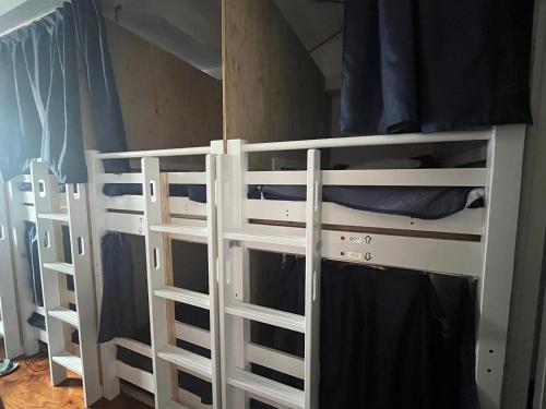two bunk beds in a room with blue curtains at Hostel Bedgasm in Tokyo