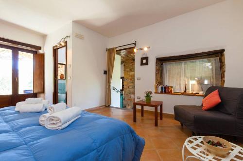 ein Wohnzimmer mit einem blauen Bett und einem Sofa in der Unterkunft Il Mosaico - Bilocale - 1 camera da letto - 1 bagno - soggiorno cucina - in zona esclusiva in Castellammare di Velia