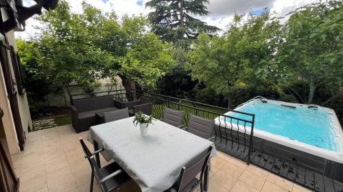 un patio avec une table et une piscine dans l'établissement Grande Villa avec Spa 10m2, à LʼHay-les-Roses