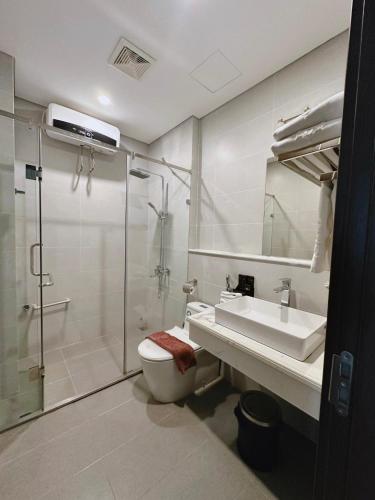 a bathroom with a shower and a toilet and a sink at Queen Hotel Hoàng Gia in Thái Nguyên