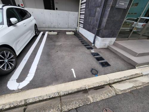 een witte auto geparkeerd voor een gebouw bij trive meieki nishi 106 最大6名宿泊可 名古屋駅まで1駅 太閤通駅徒歩4分 角部屋 無料駐車場付き in Nagoya