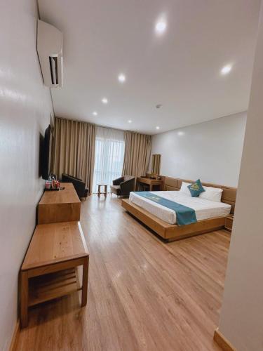 a bedroom with a bed and a living room at Queen Hotel Hoàng Gia in Thái Nguyên