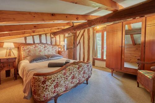 a bedroom with a bed and a chair in a room at Le Moutou - Maison avec piscine in Tombeboeuf