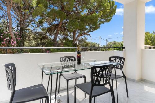 a patio with a table and chairs on a balcony at Miralis Apartments in Nikiana