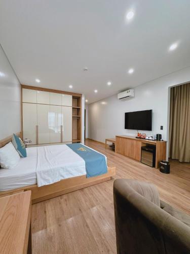 a bedroom with a large bed and a flat screen tv at Queen Hotel Hoàng Gia in Thái Nguyên