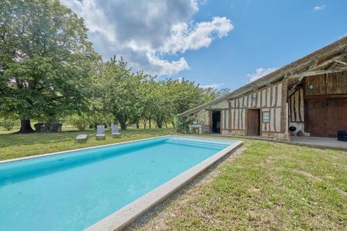 une image d'une piscine devant une grange dans l'établissement Le Moutou - Maison avec piscine, à Tombeboeuf