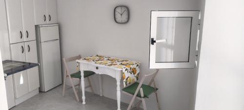 a kitchen with a table and two chairs and a clock at Divertida y Romántica in Pegalajar