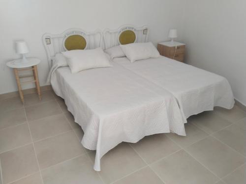 a bedroom with a white bed with two pillows at Divertida y Romántica in Pegalajar