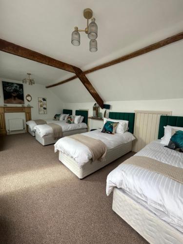 a bedroom with three beds in a room at Fitzgeralds - Ballybunion - Sleeps 34 in Ballybunion