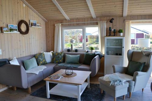 a living room with a couch and a table at Ferienhaus "Deichglück" direkt an der Nordsee 2023 saniert in Wesselburenerkoog