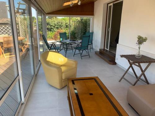 une véranda avec une chaise et une table dans l'établissement Maison spacieuse 120 m plage de la grève blanche, à Plouguerneau