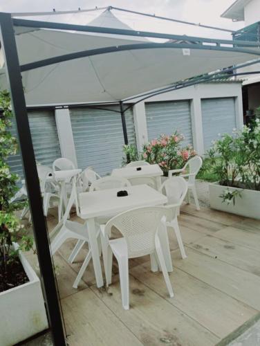 a group of white tables and chairs on a patio at La Casera in Lido di Dante