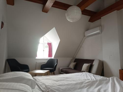 a bedroom with a bed and a couch and a window at Katerina Vendégház in Tihany