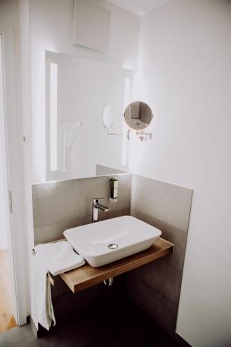 a bathroom with a white sink and a mirror at Zur Pfanne – Studio in Biberach an der Riß