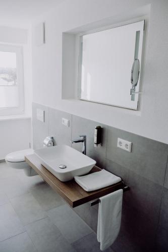 a white bathroom with a sink and a toilet at Zur Pfanne – Studio in Biberach an der Riß