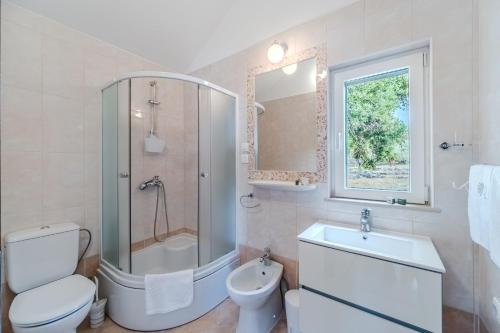 a bathroom with a shower and a toilet and a sink at Holiday home Horizont in Supetar
