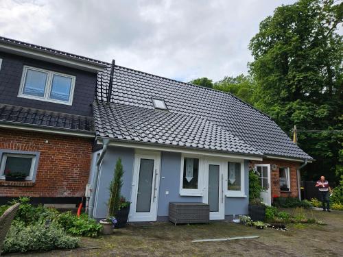ein Haus mit grauem Dach in der Unterkunft Ferienwohnung 1 Am Park in Divitz