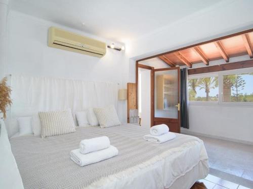 a bedroom with a large bed with two towels on it at Ca sa Padrina in Colonia Sant Jordi
