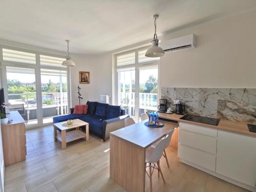eine Küche und ein Wohnzimmer mit einem Sofa und einem Tisch in der Unterkunft Apartament Żółty Jantar - Ku Morzu in Sianożęty