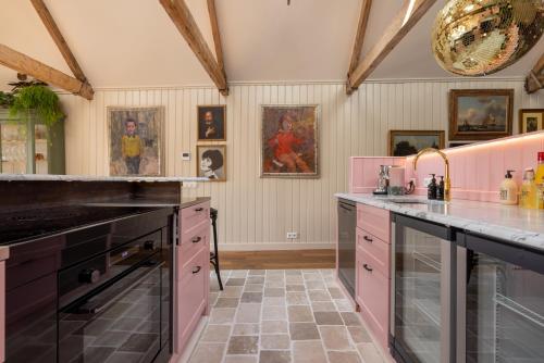 een keuken met roze kasten en roze apparaten bij Luxurious Harbour Loft d'Ouwe Moer in Rotterdam