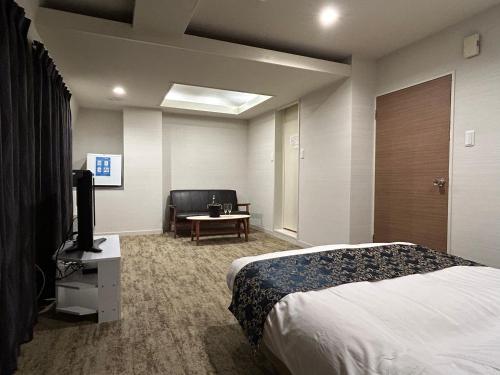 um quarto de hotel com uma cama e uma televisão em ホテルアイエス em Yokohama