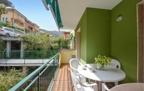 a balcony with a table and chairs and a green wall at Amazing Apartment In Moneglia With Wifi in Moneglia