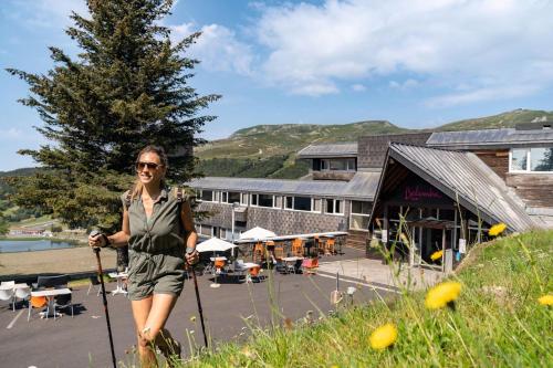 une femme se tient devant un bâtiment dans l'établissement Belambra Clubs Superbesse - Le Chambourguet, à Super-Besse