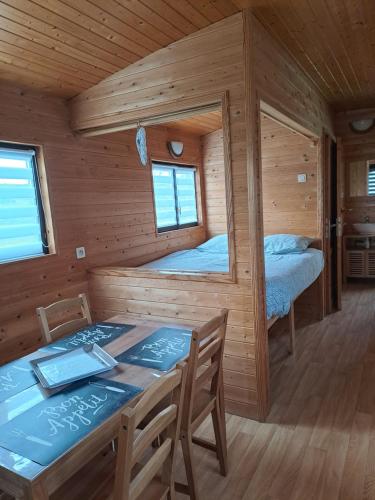 eine Holzhütte mit einem Tisch und 2 Betten in der Unterkunft Monts de flandre insolite in Berthen