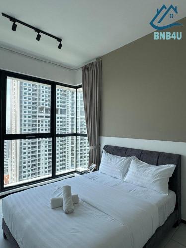 a bedroom with a large white bed with large windows at Urban Suites Georgetown by BNB4U in Jelutong