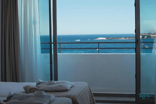 a bedroom with a bed and a view of the ocean at Typic Marina Playa - Adults Only in San Antonio Bay
