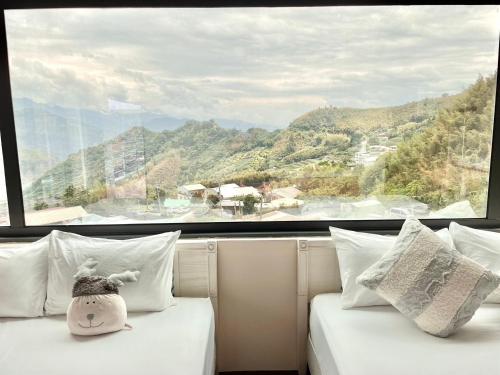 two beds in a room with a large window at Chuxu Homestay in Fanlu