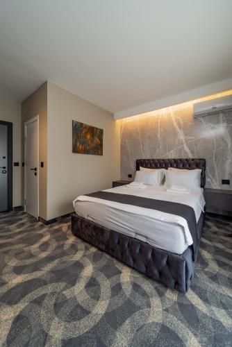 a bedroom with a large bed in a room at Forty One Suites Belgrade Apartments in Voždovac