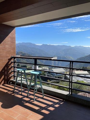 two chairs on a balcony with a view of mountains at Chuxu Homestay in Fanlu