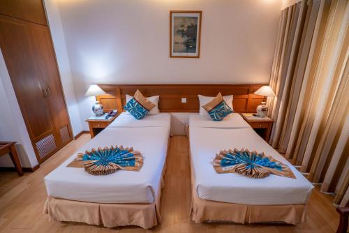 a hotel room with two beds in a room at Oscar Saigon Hotel in Ho Chi Minh City