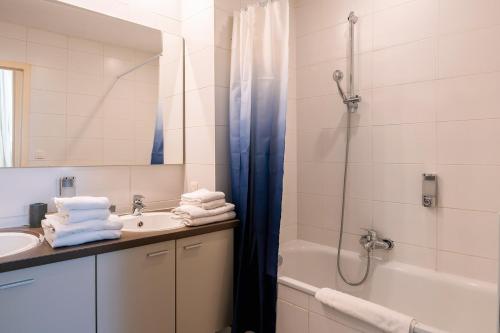 La salle de bains est pourvue d'une douche, d'un lavabo et d'une baignoire. dans l'établissement Résidence Capitale - City Center, à Bruxelles