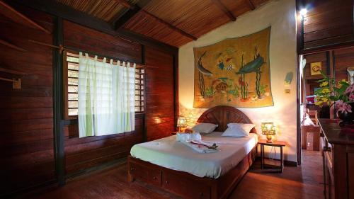 Un dormitorio con una cama y un cuadro en la pared. en Villa Razambe, en Nosy Be