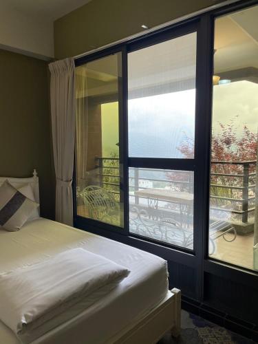 a bedroom with a bed and a large window at Chuxu Homestay in Fanlu