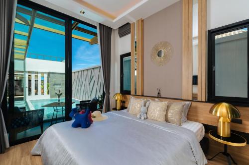 sypialnia z łóżkiem z dwoma pluszakami w obiekcie Rawayana Central Park Villas w mieście Rawai Beach