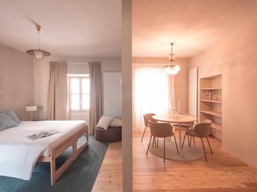 two images of a bedroom with a bed and a table at B&B CCAA Ascona in Ascona