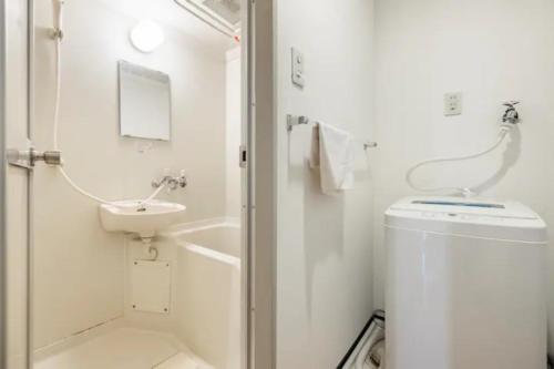 a white bathroom with a sink and a toilet at グランディオーソ中野富士見町 in Tokyo
